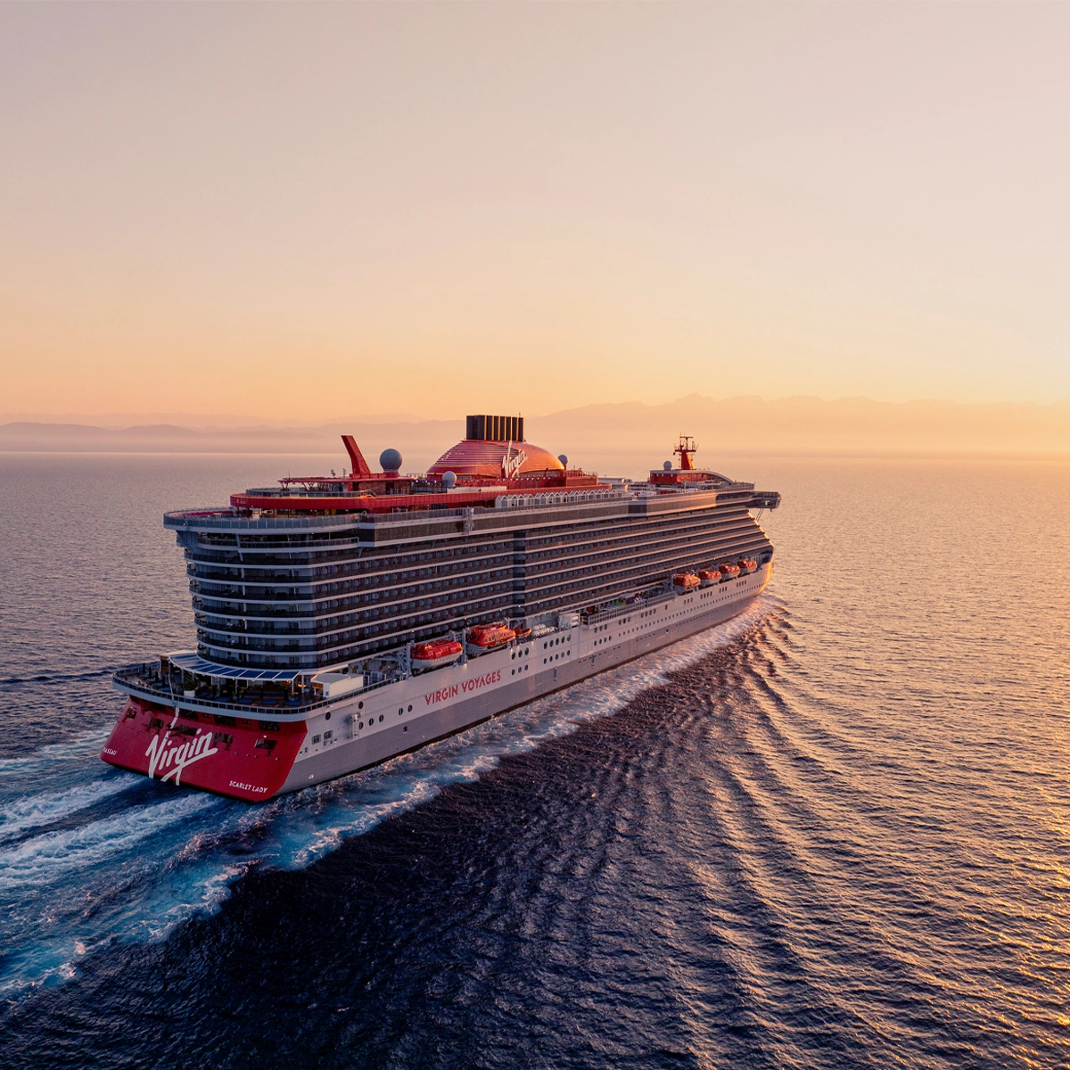 Virgin Voyages cruise ship sailing at sunset
