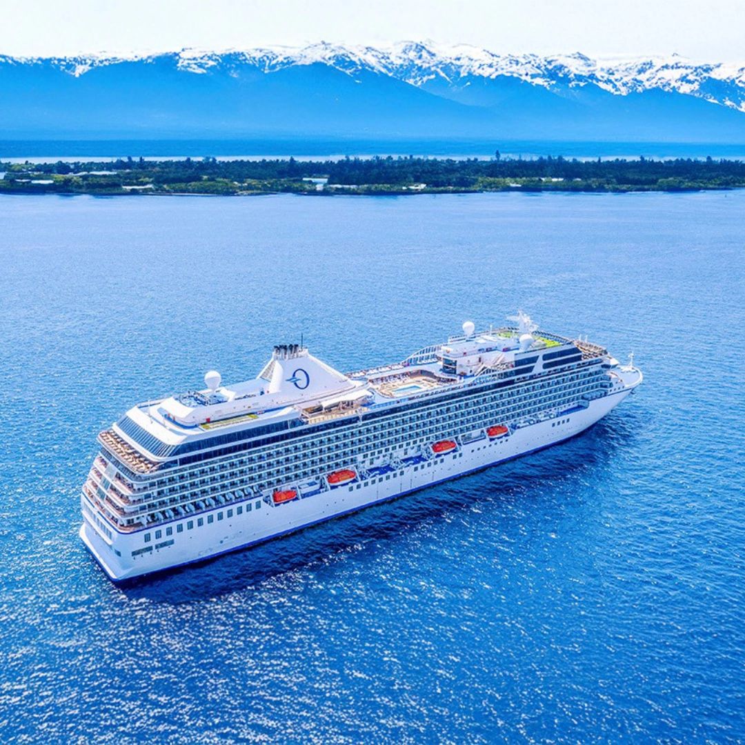 Oceania cruise ship sailing near snow-covered mountains